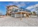 Stunning waterfront home exterior featuring elevated deck and ground-level parking area at 6417 Driftwood Dr, Hudson, FL 34667