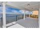 Covered waterfront patio features wood flooring and black metal railing with unobstructed views of the bay at 6417 Driftwood Dr, Hudson, FL 34667