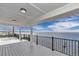 Covered waterfront patio boasts wood flooring and black metal railing with scenic views of the bay at 6417 Driftwood Dr, Hudson, FL 34667