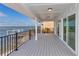 Covered waterfront patio features wood flooring and black metal railing with unobstructed views of the bay at 6417 Driftwood Dr, Hudson, FL 34667