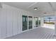 Covered waterfront patio with wood flooring and sliding glass doors that offer stunning views of the bay at 6417 Driftwood Dr, Hudson, FL 34667