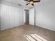 Neutral-toned empty bedroom with tile floors, ceiling fan, and large closet at 913 27Th E St, Bradenton, FL 34208