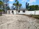 Charming white home with arched entryway, shell driveway, and tropical landscaping at 913 27Th E St, Bradenton, FL 34208