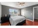 Bedroom featuring hardwood floors, a ceiling fan, a large window, and dresser storage at 10759 Keys Gate Dr, Riverview, FL 33579