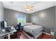 Bedroom with hardwood floors, a ceiling fan, and window view and a computer desk setup at 10759 Keys Gate Dr, Riverview, FL 33579