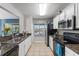 Efficient kitchen layout with white cabinets, modern appliances, and tiled flooring creates a clean and functional space at 10759 Keys Gate Dr, Riverview, FL 33579