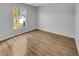 Bedroom featuring hardwood floors, neutral paint, and a window overlooking the lawn at 4903 Rambling Rose Pl, Tampa, FL 33624