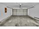 Spacious garage with a standard garage door, electrical outlets, and white painted walls at 4903 Rambling Rose Pl, Tampa, FL 33624