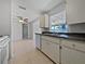 Galley kitchen with neutral cabinets, tile floors, and ceiling fan with a view into the Gathering room at 507 Circlewood Dr # O2, Venice, FL 34293