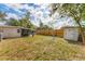 An open backyard features a shed, screened porch, grassy area and perimeter wooden fence at 5350 47Th N Ave, St Petersburg, FL 33709