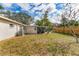 Back exterior view with a screened porch, lush green grass, and a partial wooden fence at 5350 47Th N Ave, St Petersburg, FL 33709