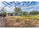 Charming single-story home featuring a spacious front yard under a blue sky with scattered clouds at 5350 47Th N Ave, St Petersburg, FL 33709