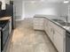 Well-lit kitchen with white cabinetry, gray countertops, stainless steel appliances, and tile flooring at 8379 Begonia St, Spring Hill, FL 34608