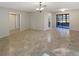 Spacious living room featuring neutral walls, tile flooring, and sliding glass doors to the screened in patio at 8379 Begonia St, Spring Hill, FL 34608