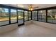 Enclosed sunroom with a ceiling fan and view of the backyard through many windows at 8379 Begonia St, Spring Hill, FL 34608