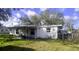 Backyard area with lawn equipment and covered patio, partially fenced at 1814 Elk Ave, Sarasota, FL 34235