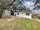 Exterior front view showing a well-maintained yard and charming home facade with mature shade trees at 2117 W Paris St, Tampa, FL 33604