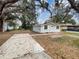 Exterior front view of the house with mature trees and parking pad at 2117 W Paris St, Tampa, FL 33604