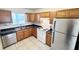 Well lit kitchen with stainless steel appliances, tile floors and wooden cabinets at 2856 Somerset Park Dr # 102, Tampa, FL 33613