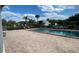 Brick pool deck with lounge chairs by the pool and verdant landscaping against the backdrop of neighborhood buildings at 2856 Somerset Park Dr # 102, Tampa, FL 33613