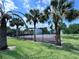 Community tennis court lined with palm trees and secured with fencing provides an active recreation area for residents to enjoy at 2856 Somerset Park Dr # 102, Tampa, FL 33613