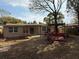 Backyard featuring a red bench, mature trees, and a partial view of the home's exterior at 4325 Newbury Dr, New Port Richey, FL 34652
