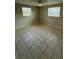 Simple bedroom with tile flooring, a ceiling fan, and natural light from two windows at 4325 Newbury Dr, New Port Richey, FL 34652