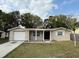 Charming single-story home with a front lawn, attached garage, and covered entryway supported by columns at 4325 Newbury Dr, New Port Richey, FL 34652