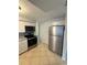 Bright kitchen featuring modern stainless steel appliances, white cabinets, and tiled flooring at 4325 Newbury Dr, New Port Richey, FL 34652