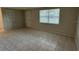 Spacious, empty living room featuring tiled floors and natural light from the window at 4325 Newbury Dr, New Port Richey, FL 34652