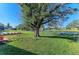 Sprawling green backyard featuring a large tree and serene canal views, enclosed by a chain-link fence at 408 43Rd Street W Blvd, Palmetto, FL 34221