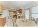 Eat-in kitchen with wood cabinetry, white appliances, and ample natural light from a nearby window at 408 43Rd Street W Blvd, Palmetto, FL 34221