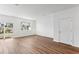 Living room with wood-look flooring, natural light, and a sliding door to the backyard at 11840 Sylvia St, Dade City, FL 33525