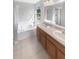 Bright bathroom with a tub, shower and a double sink vanity with a large mirror at 12549 Chenwood Ave, Hudson, FL 34669