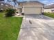 Inviting two-story home showcasing a two-car garage, lush lawn, and well-maintained landscaping at 12549 Chenwood Ave, Hudson, FL 34669