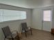 Bright room with two chairs, a large window with blinds, and a door with a window at 6050 Coral Way # 4, Bradenton, FL 34207