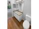 Bathroom with a long vanity and mirror, wood-look flooring and a white toilet at 8103 Rhanbuoy Rd, Spring Hill, FL 34606