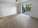 A light-filled bedroom featuring neutral carpet, fan, and sliding glass door to the backyard at 8103 Rhanbuoy Rd, Spring Hill, FL 34606