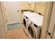 Bright laundry room with washer, dryer, and utility sink at 20590 Granlago Dr, Venice, FL 34293