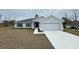 New construction home with gray exterior, two-car garage, and landscaped yard at 13106 Nusser Ave, Weeki Wachee, FL 34614