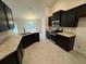 Modern kitchen with dark cabinets, granite countertops, and stainless steel appliances at 13106 Nusser Ave, Weeki Wachee, FL 34614