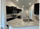 Modern kitchen with dark cabinets and granite countertops at 13106 Nusser Ave, Weeki Wachee, FL 34614