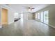 Spacious living area with tile flooring, ceiling fans, and sliding glass doors at 8531 Bass Lake Dr, New Port Richey, FL 34654