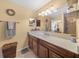 Bathroom with dark brown vanity, tiled floors and a large mirror at 221 111 E St, Bradenton, FL 34212