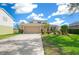 Two-story house with tan garage door, landscaping, and driveway at 221 111 E St, Bradenton, FL 34212