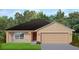 One-story house with a brown roof, beige walls, and a two-car garage at 13221 Gulf Bay Ln, Spring Hill, FL 34609