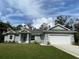 Newly constructed one-story home with gray siding, a two-car garage, and a well-manicured lawn at 7724 Swiss Ave, North Port, FL 34291