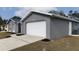 Gray house with white garage door and landscaping at 12117 Topaz St, Spring Hill, FL 34608