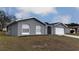 Gray house with white garage door and landscaping at 12117 Topaz St, Spring Hill, FL 34608