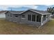 Gray house exterior with a screened porch and landscaping at 12117 Topaz St, Spring Hill, FL 34608